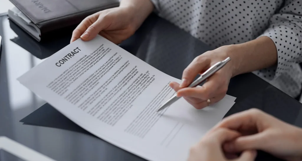 Za radnim stolom advokat pokazuje klijentu na papir koji se odnosi na upis prava svojine.