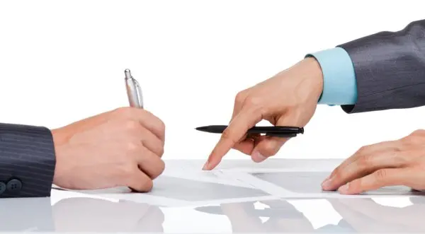 Advokat prstom pokazuje klijentu gde da potpiše aneks ugovora o radu.